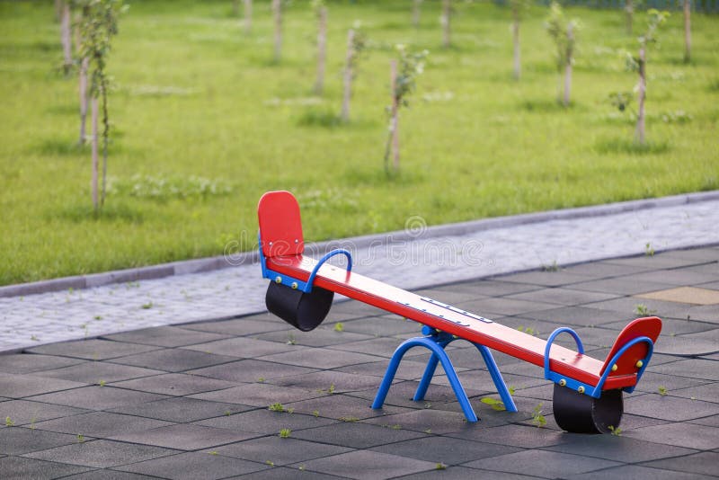 Seesaw Swing In Big Yard With Soft Rubber Flooring On Sunny Summer Day Stock Photo Image Of Ground Childhood 154403222