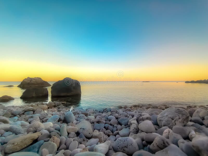 Seesonnenuntergangseehimmel stonesthree große Steine in den Gewässern. lizenzfreies stockfoto