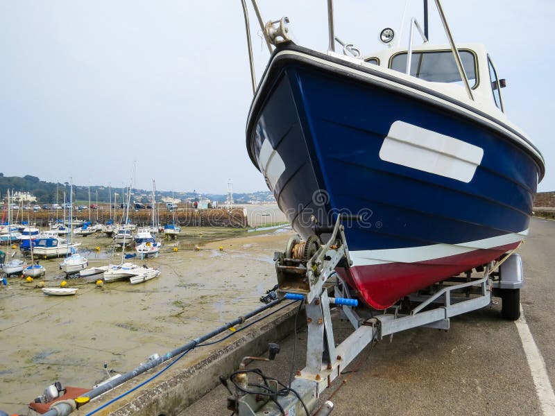 Segelboot auf einem Anhänger im Hafen St Aubin lizenzfreie stockbilder Segelboot auf einem Anhänger im Hafen St Aubin lizenzfreie stockbilder
