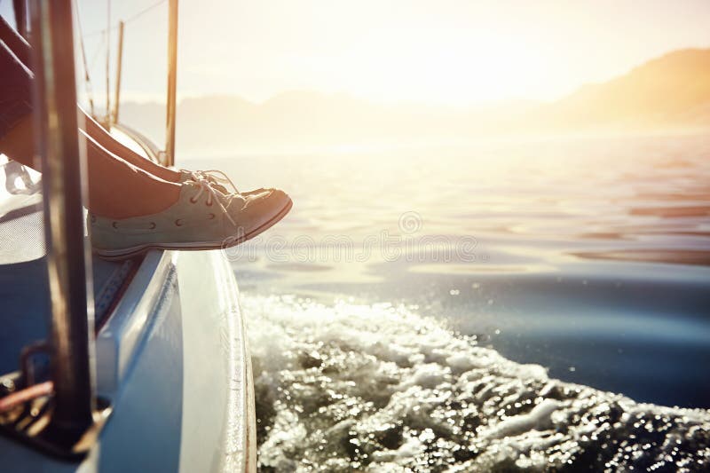 Feet on boat sailing at sunrise lifestyle. Feet on boat sailing at sunrise lifestyle