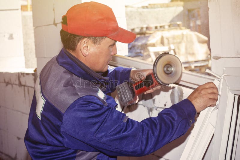 Seghe di plastica funzionanti di funzionamento della finestra dell'installazione che costruiscono una casa immagini stock Seghe di plastica funzionanti di funzionamento della finestra dell'installazione che costruiscono una casa immagini stock