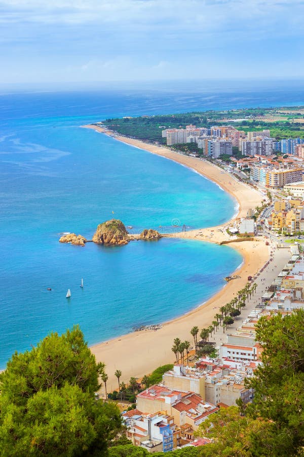 Segla utmed kusten strandsemesterorten Blanes, slotten San Juan, Spanien. Vagga Sa Palomera på kust av den spanska strandsemesterorten Blanes i sommartid Solig sikt från höjd av berget av slotten San Juan Costa Brava, Catalonia, Spanien