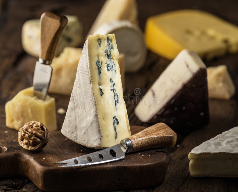 Segmento di formaggio blu o di formaggio cambozola su cartone di legno. formaggi diversi sullo sfondo immagini stock libere da diritti