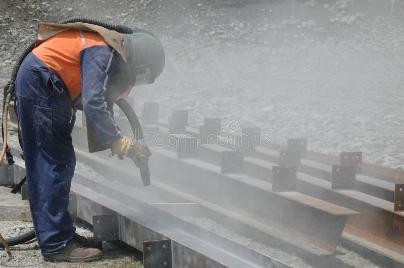 Tradesman sandblasting I beams for building project. Tradesman sandblasting I beams for building project