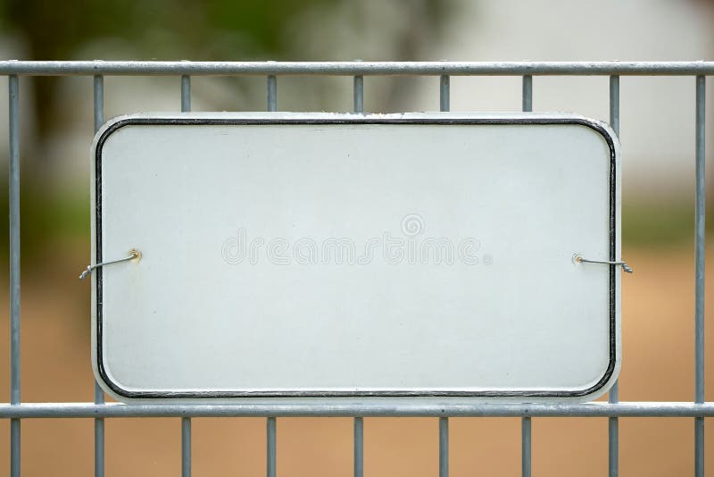 White unmarked sign on a fence with space for text. White unmarked sign on a fence with space for text