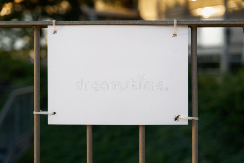 White unmarked sign on a fence with space for text. White unmarked sign on a fence with space for text