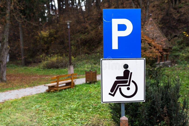 Segno blu di parcheggio per le persone disabili al parco della città fotografia stock libera da diritti Segno blu di parcheggio per le persone disabili al parco della città fotografia stock libera da diritti