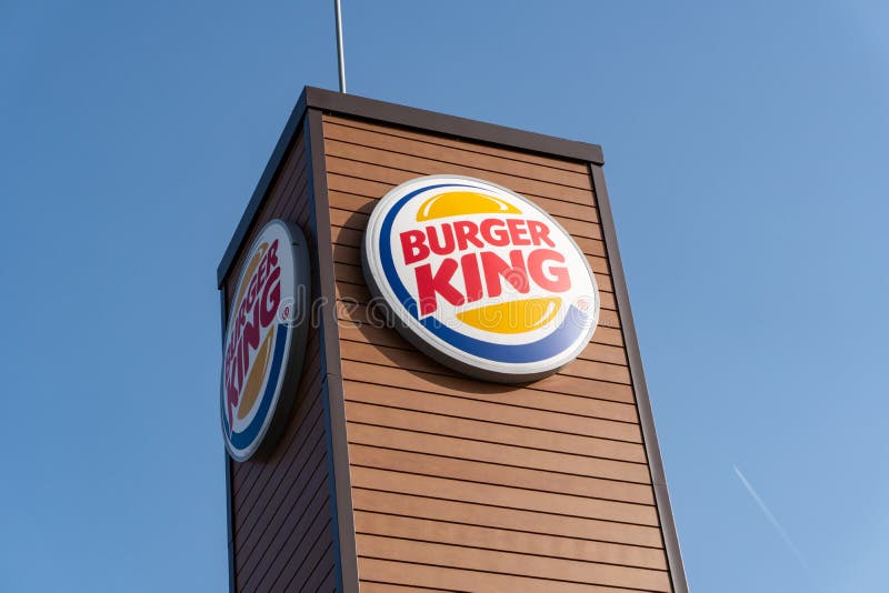 Segno di Burger King su all'aperto con il fondo del cielo blu immagini stock Segno di Burger King su all'aperto con il fondo del cielo blu immagini stock