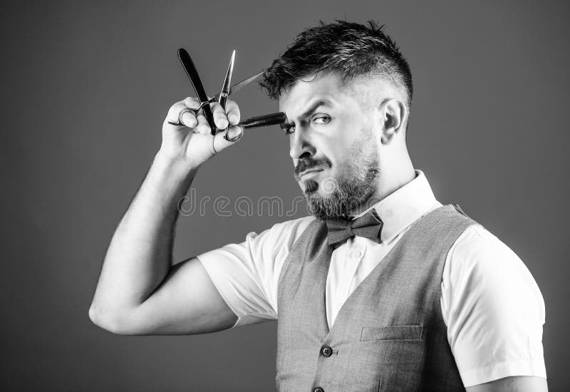 Segreti del barbiere Barbiere che tiene gli strumenti d'annata del barbiere Uomo barbuto con il rasoio e forbici in retro parrucc fotografia stock libera da diritti Segreti del barbiere Barbiere che tiene gli strumenti d'annata del barbiere Uomo barbuto con il rasoio e forbici in retro parrucc fotografia stock libera da diritti