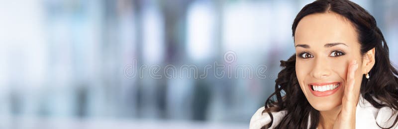 Very happy, excited surprised businesswoman in white confident clothing, over blurred modern office background. Happy smiling brunette woman covering her mouth with hand, indoor. Business ad concept. Very happy, excited surprised businesswoman in white confident clothing, over blurred modern office background. Happy smiling brunette woman covering her mouth with hand, indoor. Business ad concept