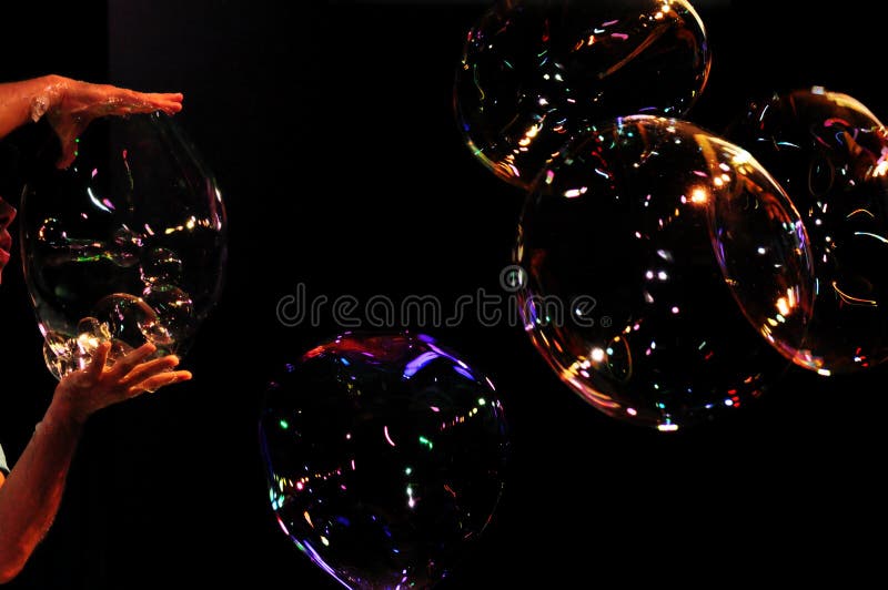 Colorful bubbles on dark background. Artist on stage is performing show. Colorful bubbles on dark background. Artist on stage is performing show.