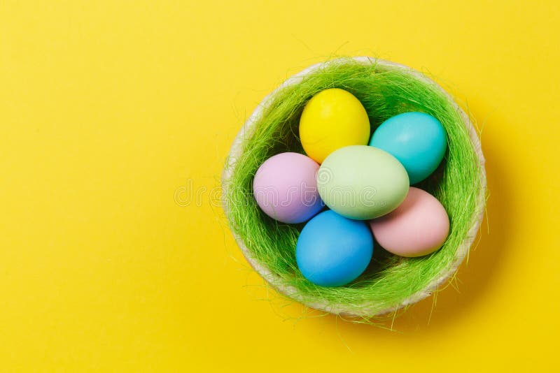 Seis huevos de Pascua pintados monofónicos en colores pastel coloridos en cesta con la hierba verde aislada en fondo amarillo Fel imagen de archivo Seis huevos de Pascua pintados monofónicos en colores pastel coloridos en cesta con la hierba verde aislada en fondo amarillo Fel imagen de archivo