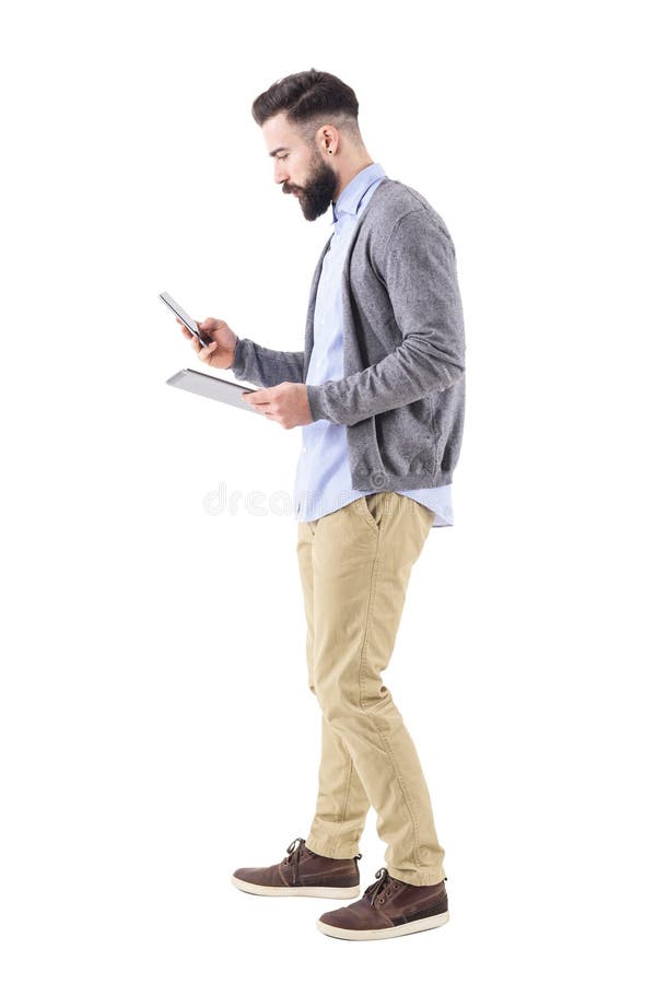 Seitenansicht des beschäftigten bärtigen Geschäftsmannes unter Verwendung der Tablette und des intelligenten Telefongehens stockfotografie Seitenansicht des beschäftigten bärtigen Geschäftsmannes unter Verwendung der Tablette und des intelligenten Telefongehens stockfotografie