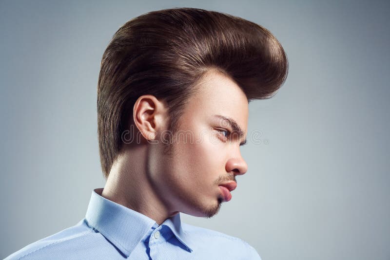 Seitenansicht des jungen Mannes mit Retro- klassischer Pompadourfrisur stockfotografie Seitenansicht des jungen Mannes mit Retro- klassischer Pompadourfrisur stockfotografie