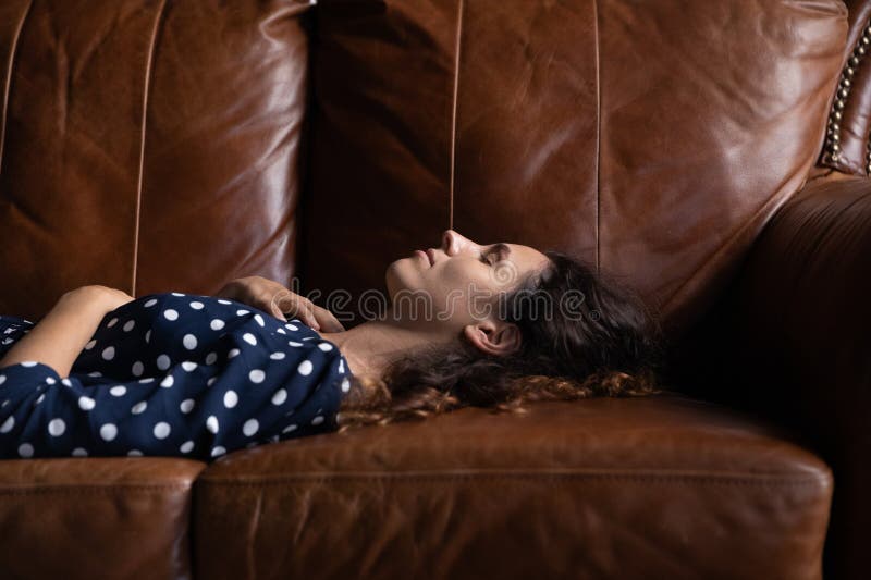 Seitenansicht friedliche attraktive Frau liegt auf einem gemütlichen Sofa stockfotos