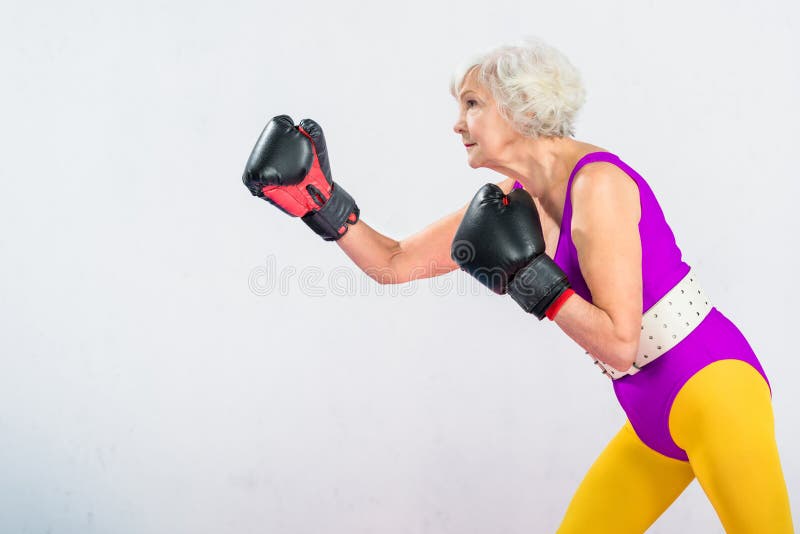 Seitenansicht sportlicher älterer Dame im Sportkleidungsverpacken lizenzfreies stockbild Seitenansicht sportlicher älterer Dame im Sportkleidungsverpacken lizenzfreies stockbild