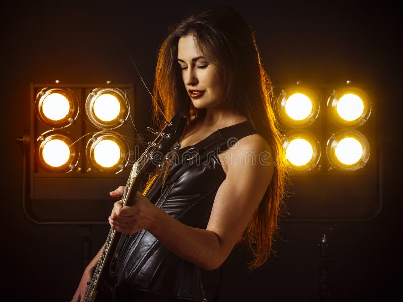 Seksowna kobieta bawić się gitarę elektryczną na scenie zdjęcia stock Seksowna kobieta bawić się gitarę elektryczną na scenie zdjęcia stock