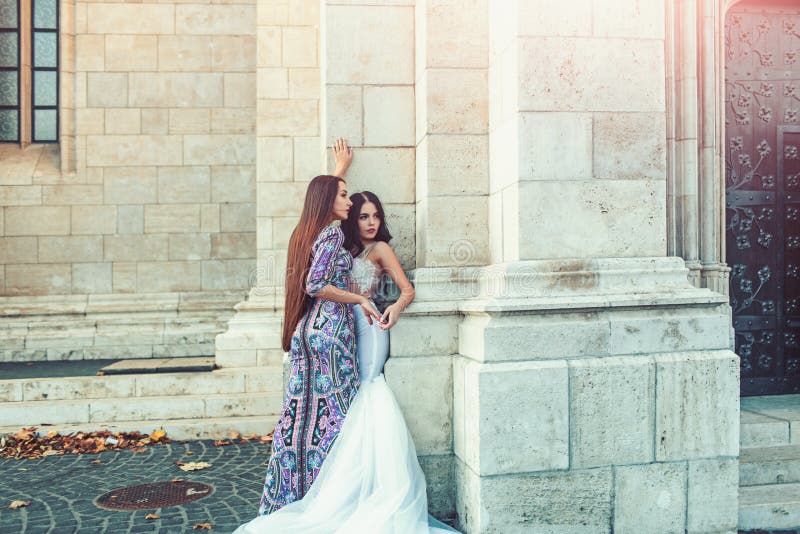 Seksowne dziewczyny w sukni z eleganckim włosy seksowna dziewczyny poza przy kamienną kolumną w ślubie i moda ubieramy fotografia stock Seksowne dziewczyny w sukni z eleganckim włosy seksowna dziewczyny poza przy kamienną kolumną w ślubie i moda ubieramy fotografia stock
