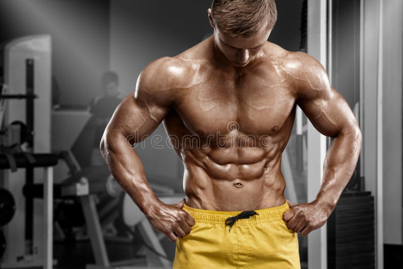 Seksowny sportowy mężczyzna pokazuje mięśniowego ciało i sixpack abs w gym Silna samiec nacked półpostać, pracująca out
