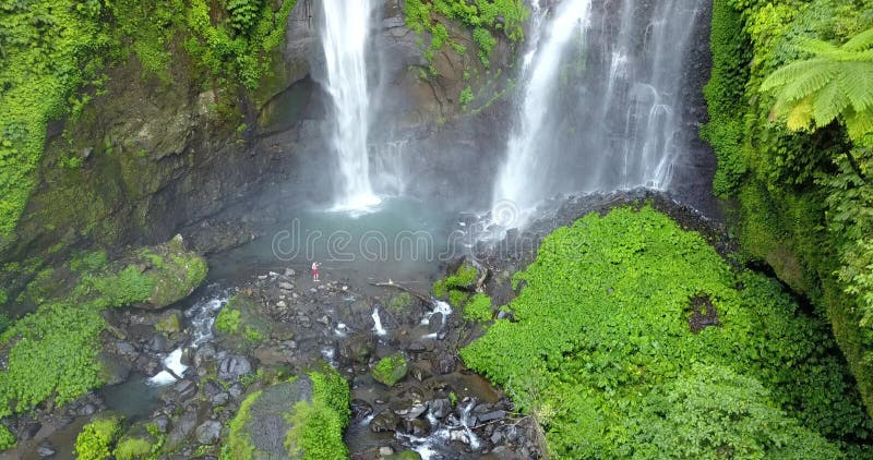 Sekumpul Waterfall in Bali with a men, Indonesia. Drone aerial Shot