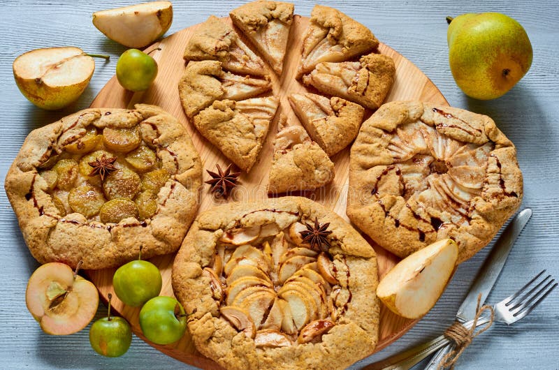 Selbst gemachte Fruchttörtchen mit dem Schokoladenbelag verziert mit Weinlesemesser und -gabel auf dem konkreten Hintergrund Vege lizenzfreies stockbild Selbst gemachte Fruchttörtchen mit dem Schokoladenbelag verziert mit Weinlesemesser und -gabel auf dem konkreten Hintergrund Vege lizenzfreies stockbild
