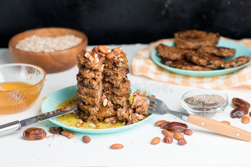 Selbst gemachte Hafermehlbananenpfannkuchen mit chia Samenmandelpflaumen und XML-Daten nieselten mit Honig und wehgetan Schalenfrü lizenzfreie stockfotos