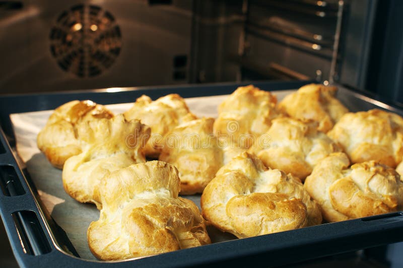 Selbst gemachte profiteroles im Ofen Prozess von Backenplätzchen, französischer Nachtisch, Süßigkeitenhintergrund