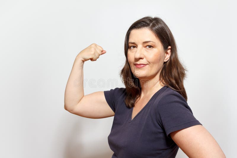 Selbstbewusste Frau, die Bizepsmuskeln biegt stockfotografie Selbstbewusste Frau, die Bizepsmuskeln biegt stockfotografie