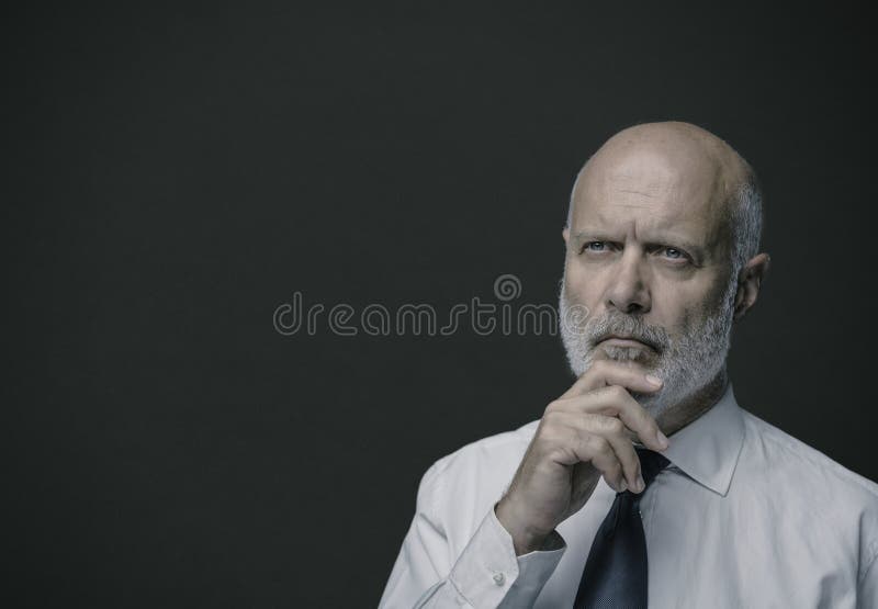 Portrait of a confident middle-aged businessman thinking with hand on chin, business strategies and leadership concept. Portrait of a confident middle-aged businessman thinking with hand on chin, business strategies and leadership concept