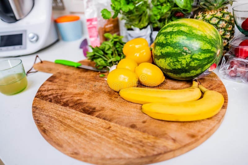 Selección de frutas y verduras frescas en tabla de cortadoras de madera con sandía de limón pimienta y hierbas perfectas para. Colorido surtido de frutas y verduras frescas incluyendo limón bananero y sandía colocado en un tablero de madera capturando una vibrante escena de cocina ideal para una vida saludable y jugo