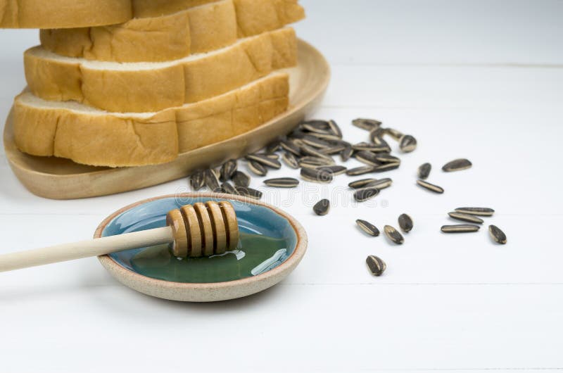Selected focus of honey with stack of bread and sunflower seeds royalty free stock photo