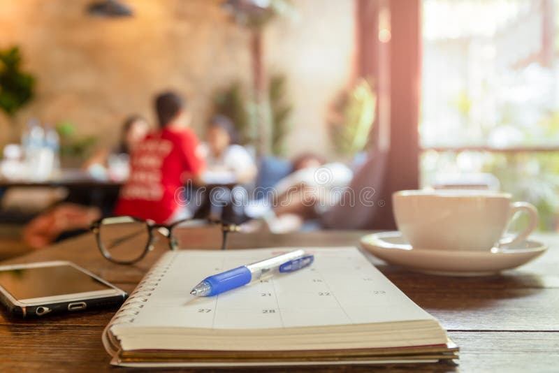 Selected focus pen on calendar book with cup of coffee and cell phone. royalty free stock image Selected focus pen on calendar book with cup of coffee and cell phone. royalty free stock image
