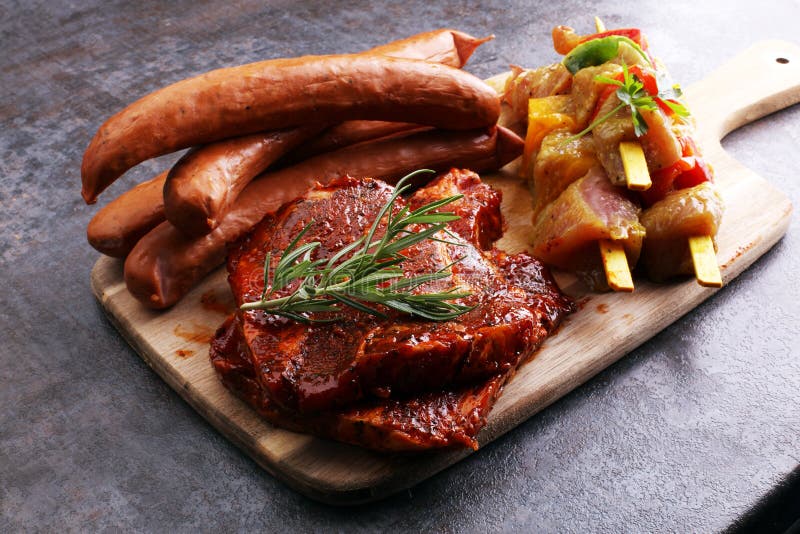 Selection of Marinaded Meat for Bbq Grilling with Herbs on Table Stock