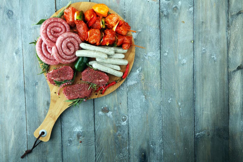 Selection of Marinaded Meat for Bbq Grilling with Herbs on Table Stock