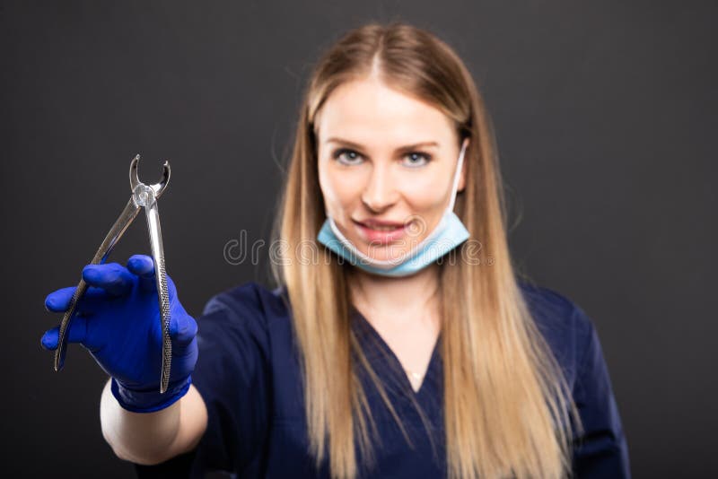 Selective focus of beautiful female dentist holding tool stock image