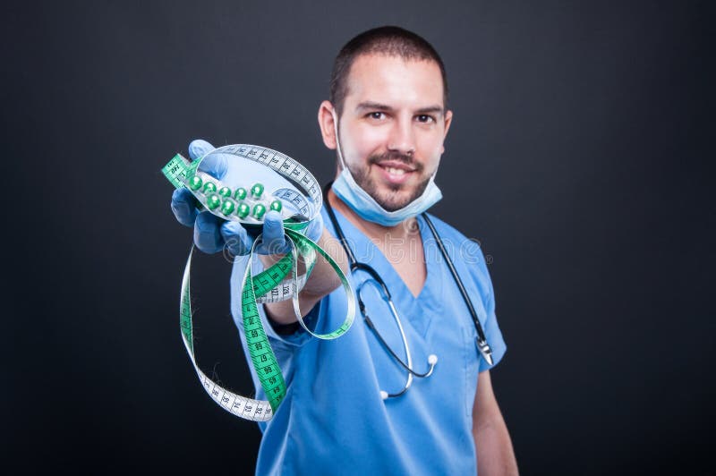 Selective focus of doctor holding pills and measuring tape royalty free stock images Selective focus of doctor holding pills and measuring tape royalty free stock images