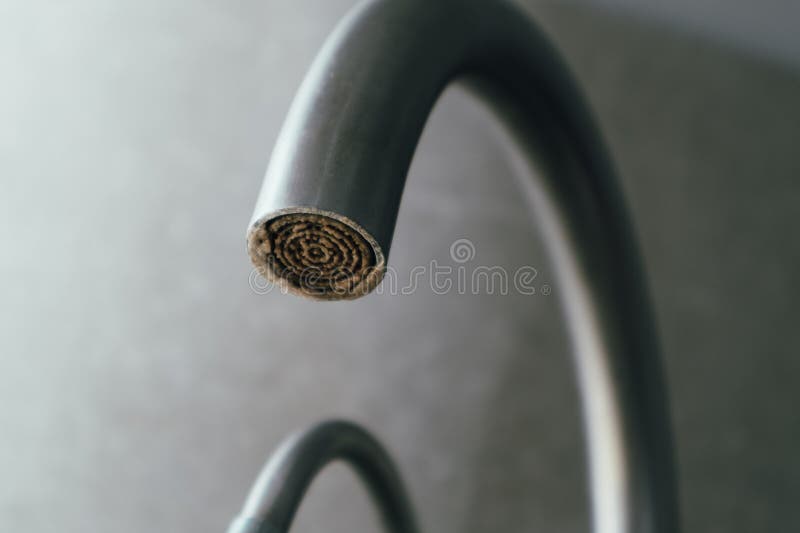 Selective focus on hard water deposit. Dirty faucet aerator with limescale, calcified shower water tap with lime scale in the royalty free stock images