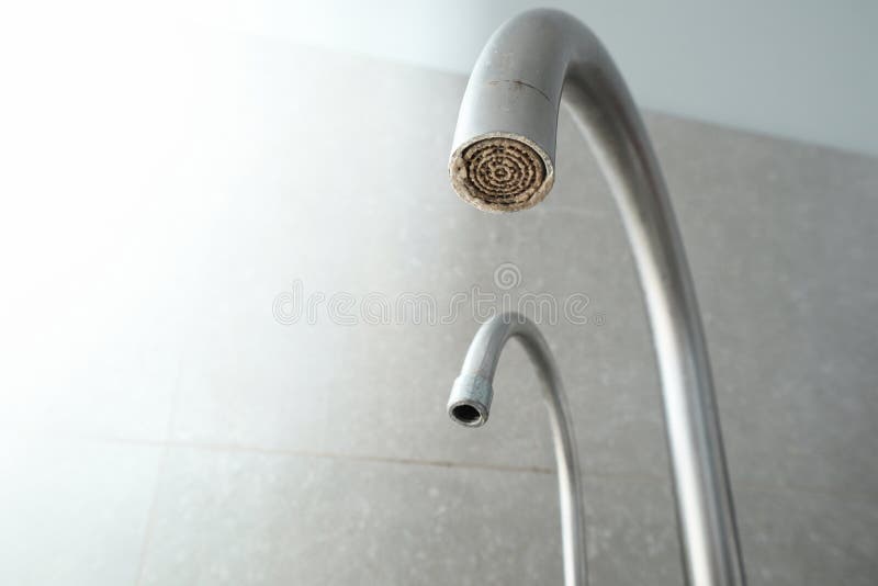 Selective focus on hard water deposit. Dirty faucet aerator with limescale, calcified shower water tap with lime scale in the royalty free stock images