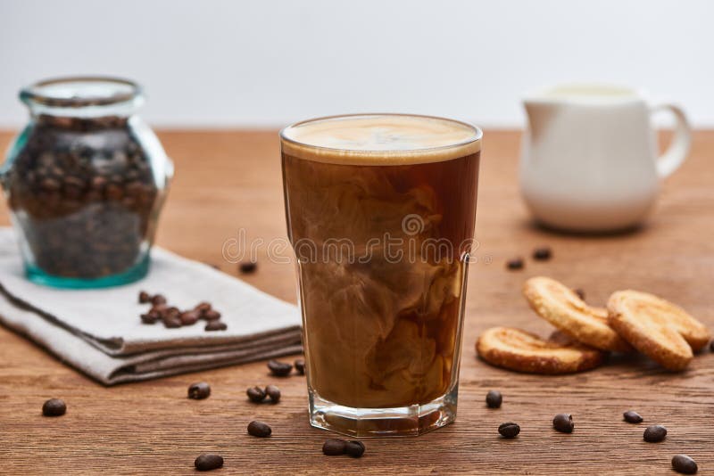 https://thumbs.dreamstime.com/b/selective-focus-ice-coffee-mixing-milk-glass-near-jug-cookies-grains-wooden-table-isolated-grey-stock-photo-174904447.jpg