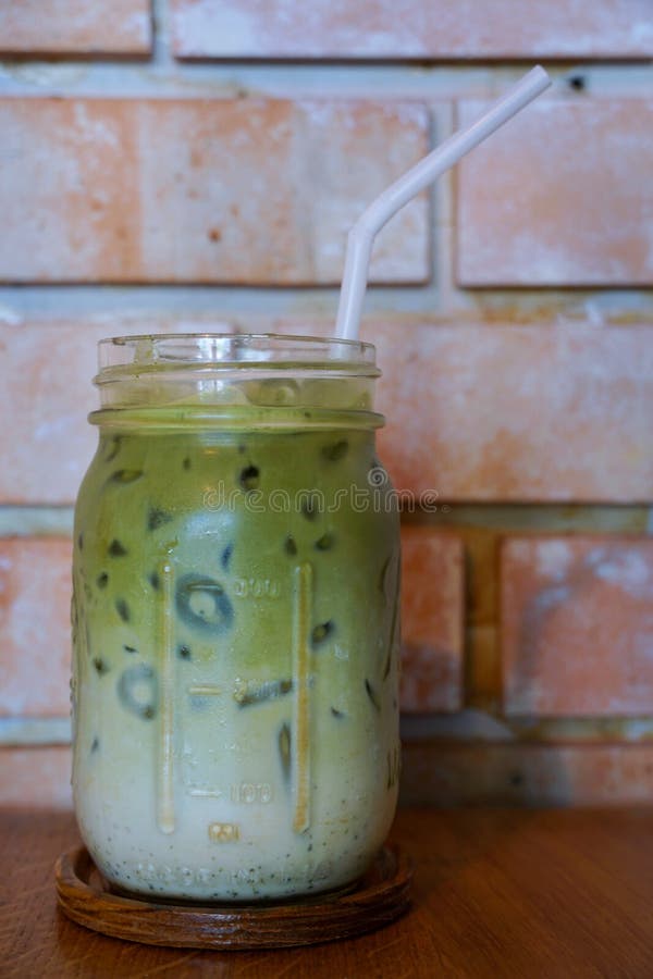 Selective focus of iced green tea in glass on wooden table stock photos Selective focus of iced green tea in glass on wooden table stock photos