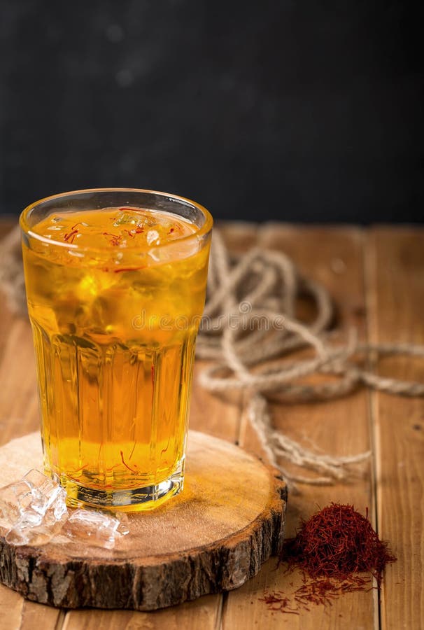 Selective Focus of an Iced Tea Glass on a Wooden Coaster with Persian