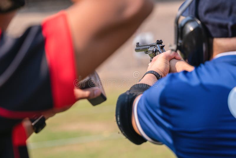 Selective focus of man holding and fire hand gun in gun shooting competition