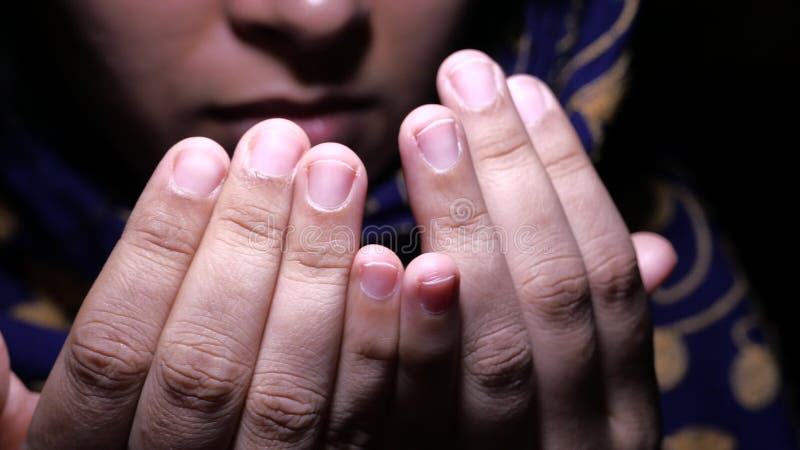 Muslim women with head scarf praying, close up