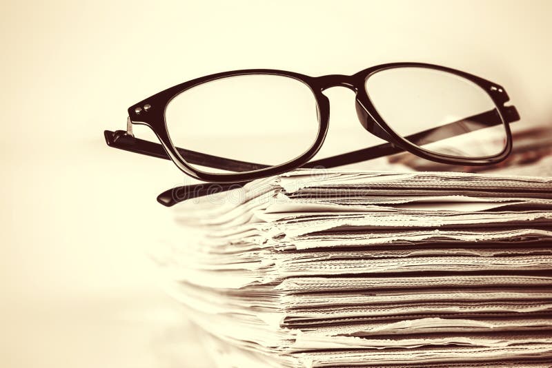Selective Focus on Reading Eyeglasses with Stacking of Newspaper Stock