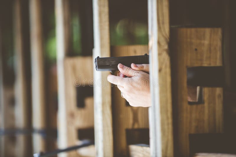 Selective focus shot of a person holding a Glock with a blurred background