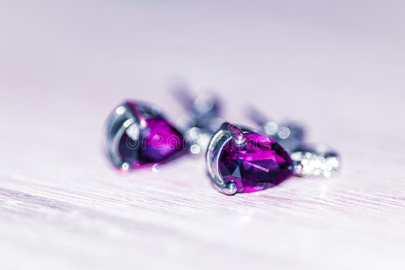Selective focus shot of stud earrings with amethyst