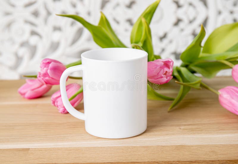 Selective focus on single one white mug mock up with spring flowers.