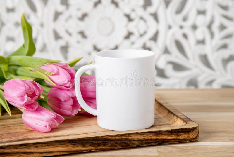 Selective focus on single one white mug mock up with spring flowers.