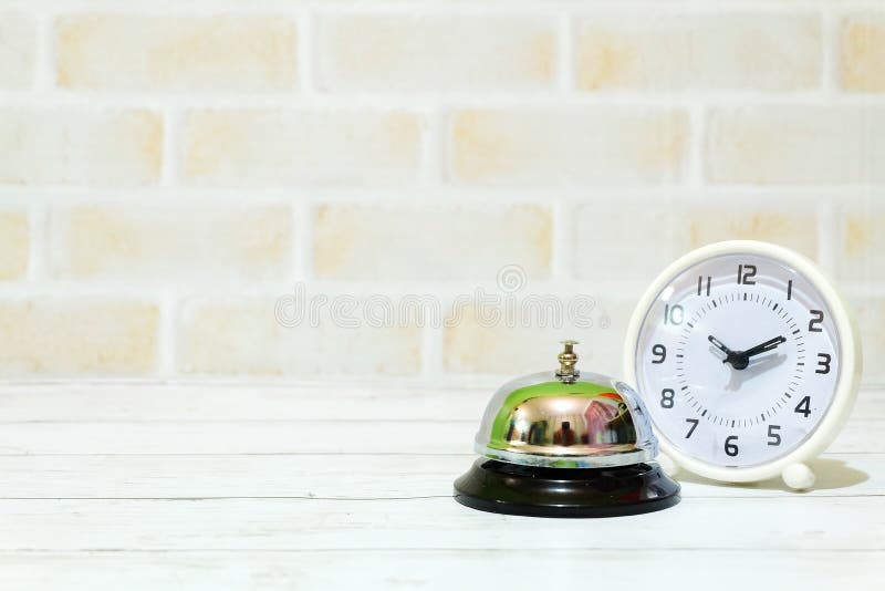 Selective focus of table clock and ring bell isolated with copy space for text. Table clock showing time ten past ten stock photography