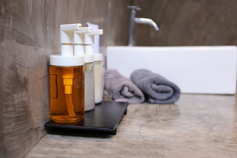 Selective focuse of Pump glass bottle with Liquid soap, shampoo, bath foam and accessories in bathroom at the luxury hotel
